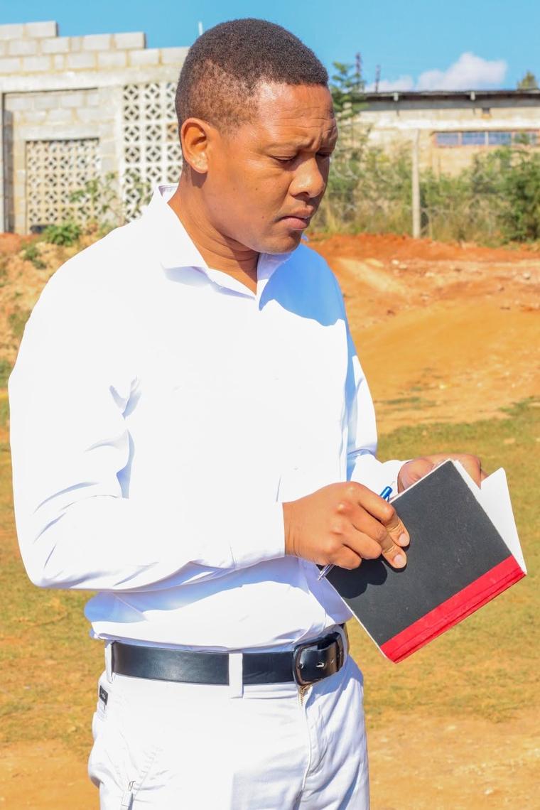 A volunteer recording details in a notebook during a community visit